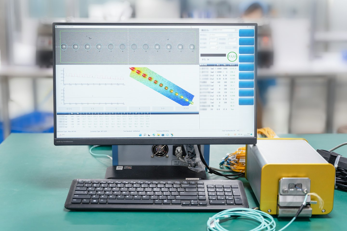 Un écran d'ordinateur affiche des graphiques techniques connectés à des machines industrielles sur un établi.